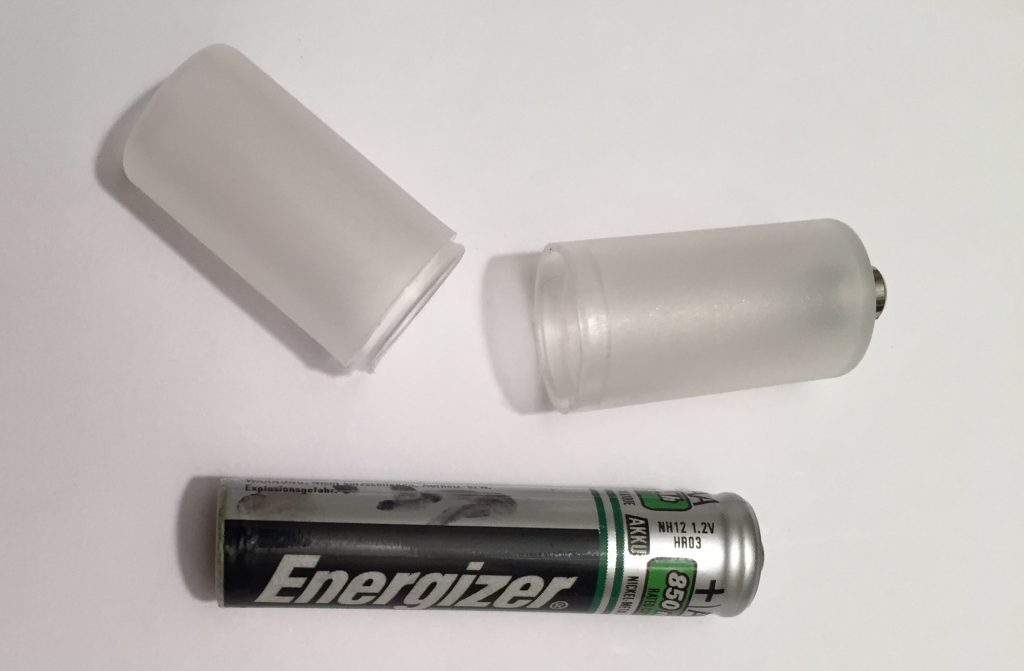 a photo of a converter tube for a AAA battery so that it fits in an AA battery slot