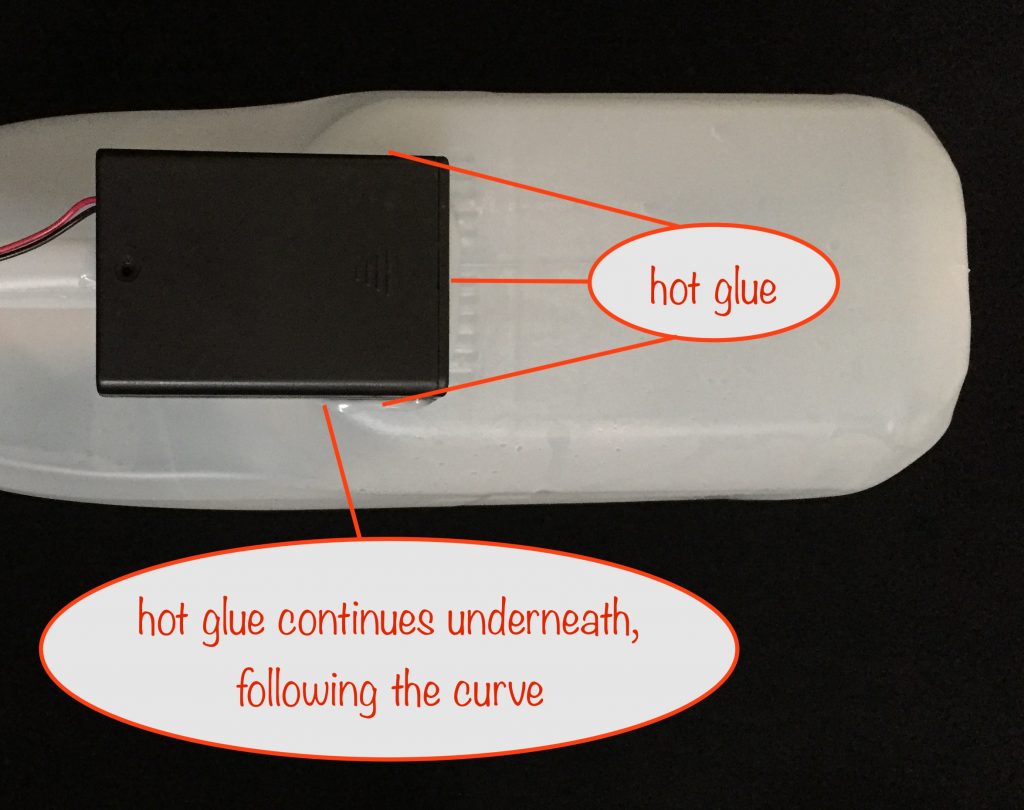 a photo showing how the battery box is hot-glued to the milk container