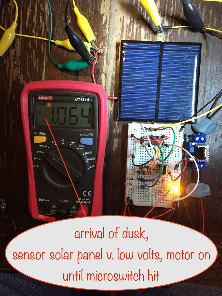 photo showing that at dusk, when the sensor solar panel is producing very low volts, the motor is on (and will remain on until the microswitch is activated, removing power from the motor)